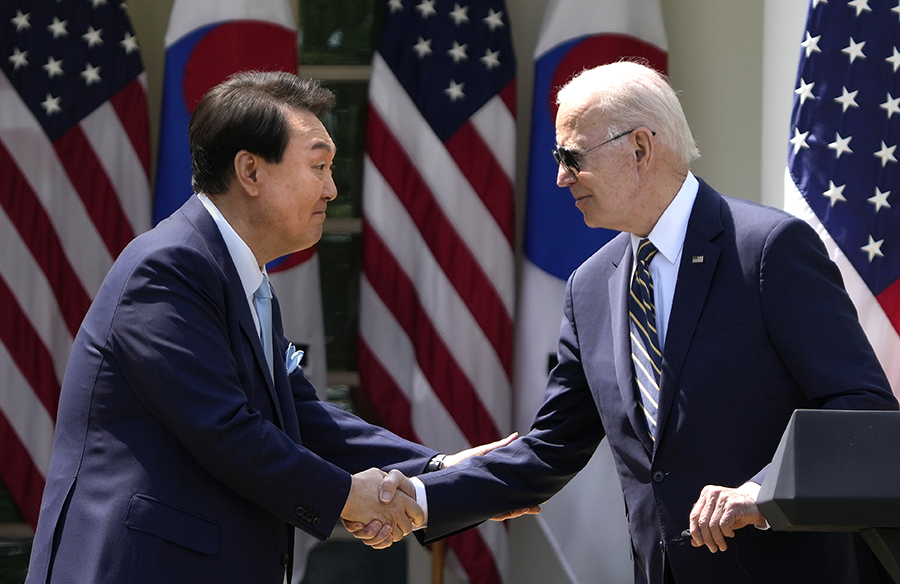 U.S. President Joe Biden (R) and South Korean President Yoon Suk Yeol shake hands during a joint press conference in the Rose Garden at the White House on April 26. (Photo by Drew Angerer/Getty Images)